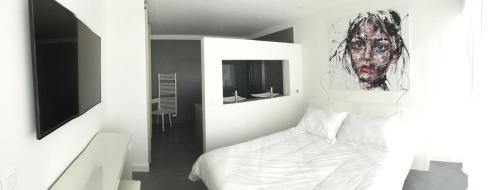 une chambre avec un lit avec un tableau sur le mur dans l'établissement Piscine chauffée, villa vue mer, proche Pinarello, à Zonza