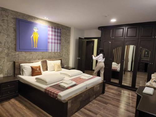 a woman standing on a bed in a room at Boutique Poo-Yai Lee in Bangkok