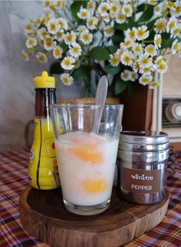 a drink in a glass on a wooden table at Boutique Poo-Yai Lee in Bangkok