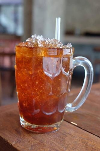 a glass mug of tea on a wooden table at Boutique Poo-Yai Lee in Bangkok