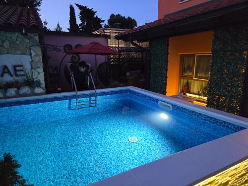 a swimming pool in front of a house at night at Bed & Breakfast Villa Adriana in Premantura