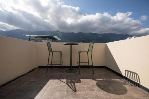 a balcony with two chairs and a table on a roof at SIXI CANGSHAN MOUNTAINS GOLDEN SUNRISE MIRROR OF THE SKY SOUND SLEEP HOTEL DALI ANCIENT CITy in Dali