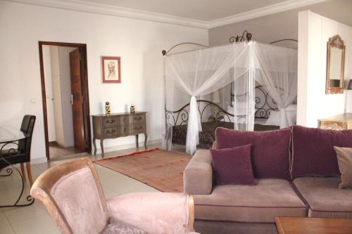 a living room with a couch and a bed at La Résidence in Dakar