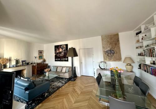 un salon avec une table en verre et un canapé dans l'établissement Beautiful Apartment with Seine and Musée d'Orsay View, à Paris
