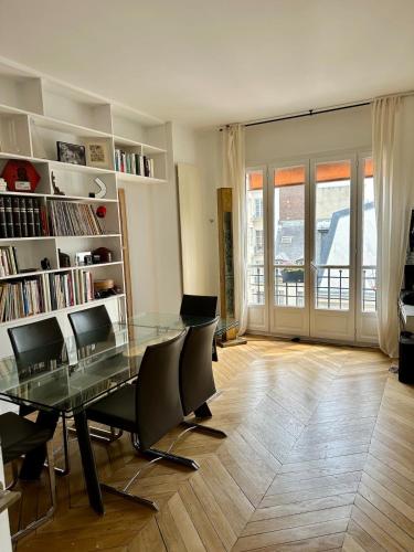 une salle à manger avec une table et des chaises en verre dans l'établissement Beautiful Apartment with Seine and Musée d'Orsay View, à Paris