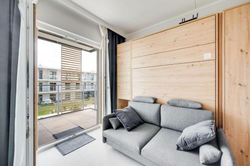 a living room with a couch and a large window at ReVital Mechelinki by Homeprime Parking Free in Mechelinki