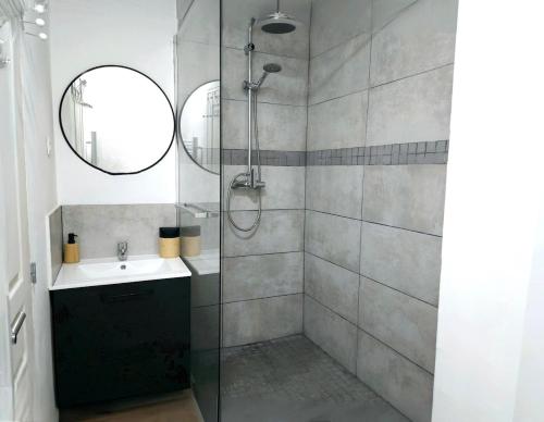 une salle de bain avec une douche avec un lavabo et un miroir dans l'établissement Logement Cosy & Spacieux Hypercentre CAEN, à Caen