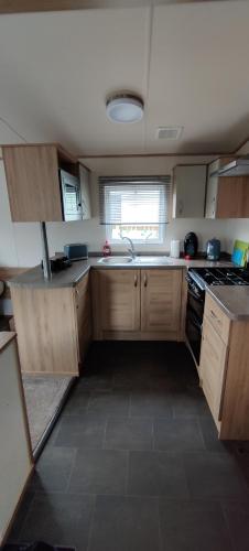 a kitchen with wooden cabinets and a sink and a stove at The Chillout in Knaresborough