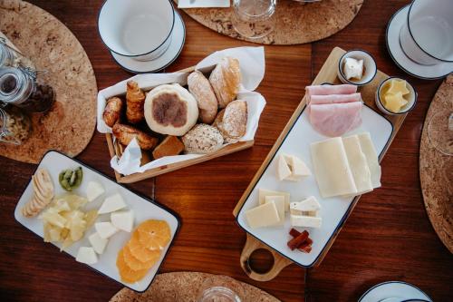 a table with two plates of cheese and other foods at Nature Retreat by Herdade do Ananás in Ponta Delgada