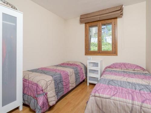 una camera da letto con due letti e una finestra di Campanal de Izas a Villanúa
