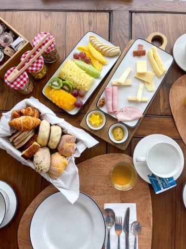 a wooden table topped with cheese and other foods at Nature Retreat by Herdade do Ananás in Ponta Delgada