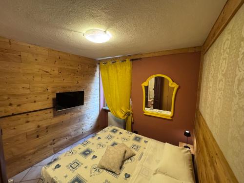 ein kleines Schlafzimmer mit einem Bett und einem Spiegel in der Unterkunft Rêve en ville in Aosta