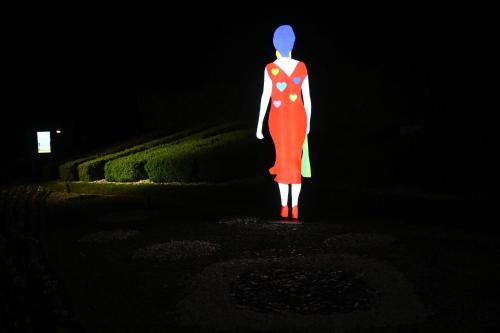 a statue of a woman in a red dress in the dark at Isola di Albarella Golf Hotel in Isola Albarella
