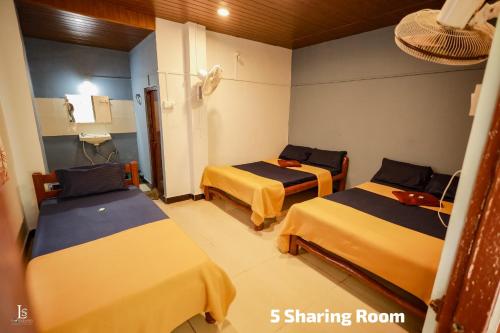 a room with three beds in a room at Adventure hill in Dandeli