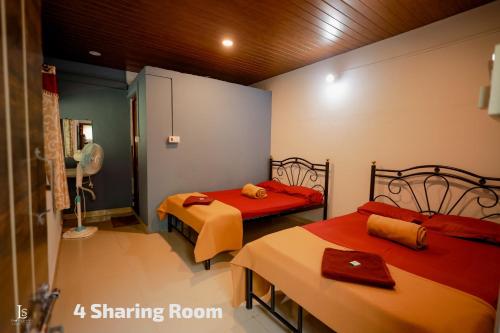 a room with two beds with red sheets at Adventure hill in Dandeli