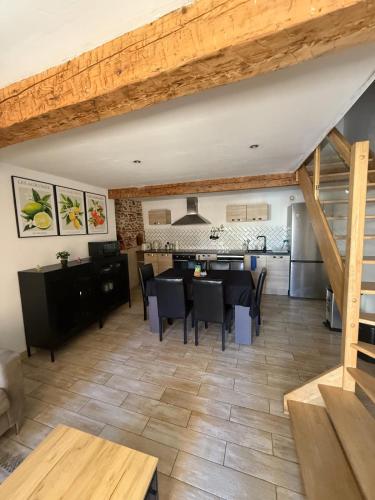 une salle à manger et une cuisine avec une table et des chaises dans l'établissement Maison Soleil - Elne, à Elne