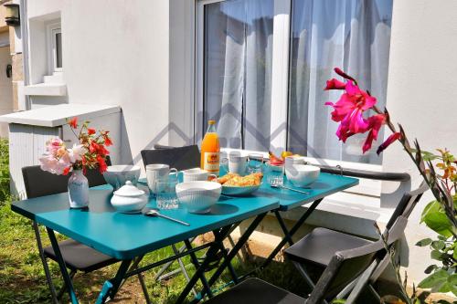 a blue table with bowls of food on it at LocaLise - M6B - Ty pompon, - Maison de vacances dans le centre du Guilvinec - extérieur clos - wifi inclus - animaux bienvenus - à deux pas des plages et du port du Guilvinec in Le Guilvinec