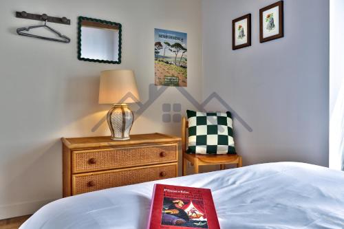 a bedroom with a bed with a lamp and a chair at LocaLise - M6B - Ty pompon, - Maison de vacances dans le centre du Guilvinec - extérieur clos - wifi inclus - animaux bienvenus - à deux pas des plages et du port du Guilvinec in Le Guilvinec
