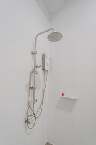 a shower head in a bathroom with a white wall at Golden Manora Hotel Bangtao Beach Phuket in Bang Tao Beach