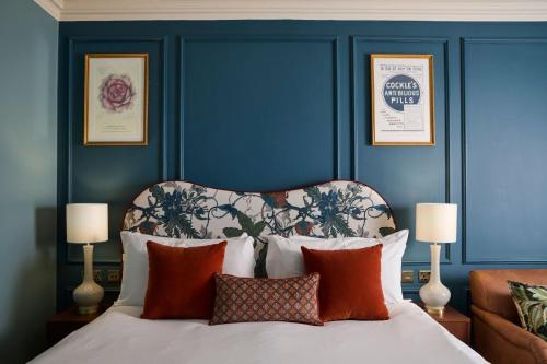 a bedroom with blue walls and a bed with pillows at Francis Hotel Bath in Bath