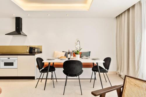 une cuisine avec une table à manger et des chaises noires dans l'établissement Suite L Ecrin Élégance confort au cœur de Cannes, à Cannes