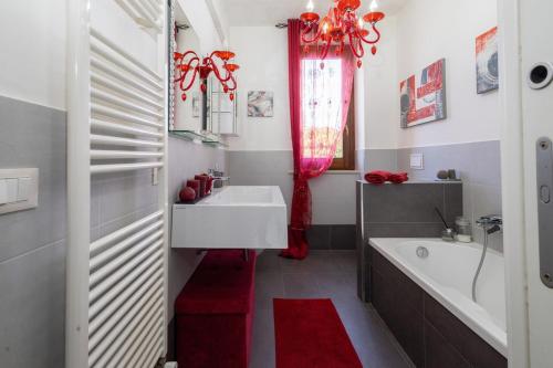 a bathroom with a white sink and a tub and a red rug at Rilassante Dimora Nel Verde - vicino a Spoleto in Castel Ritaldi