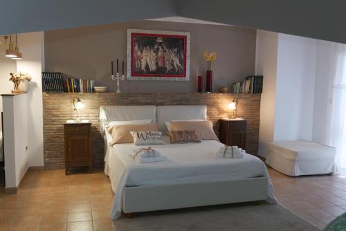 a bedroom with a white bed and a brick wall at La casa di Pierre 