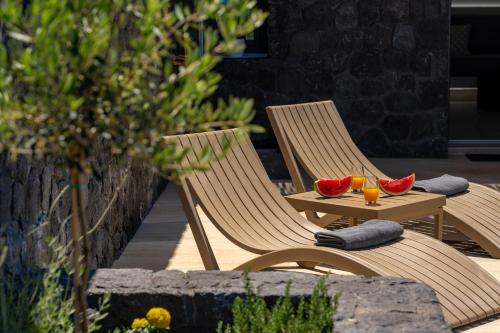 two chairs and a table with fruit on a patio at Mperes Villas in Santorini