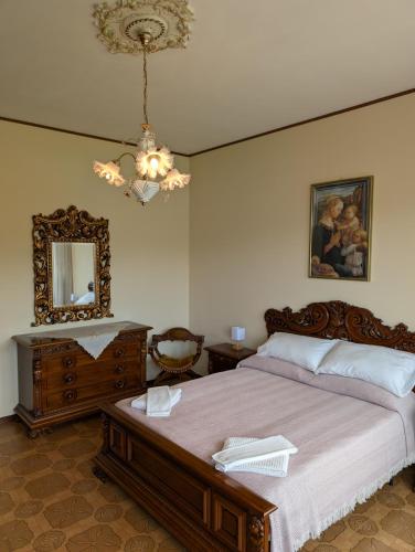 a bedroom with a bed and a mirror and a chandelier at Iseo Lake Terrace in Sale Marasino