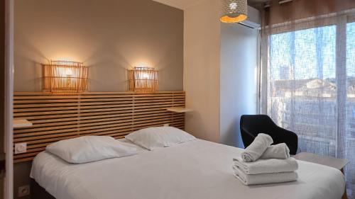 une chambre avec un lit, une chaise et une fenêtre dans l'établissement Appartement Luxueux Entre Bord de Mer & Montagne - by Résidence La Fontaine Sablettes, à La Seyne-sur-Mer