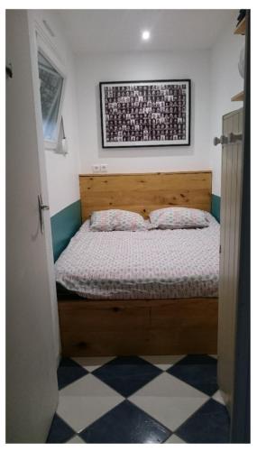 - une chambre dotée d'un lit en bois avec une photo sur le mur dans l'établissement WISSANT - Appartement avec grande terrasse, à Wissant