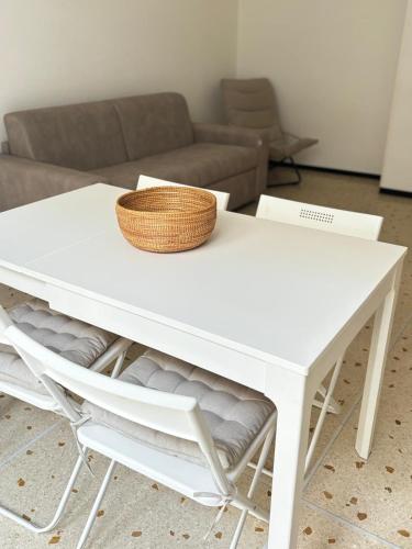 a white table and chairs with a basket on top at Cà di Scirocco in Varigotti