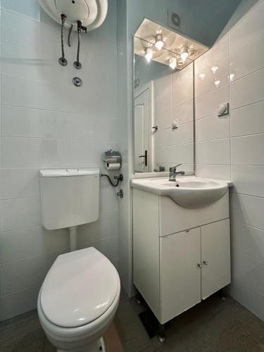 a white bathroom with a toilet and a sink at Beach Bliss in Utjeha