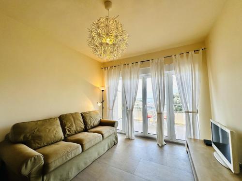 a living room with a couch and a chandelier at Beach Bliss in Utjeha