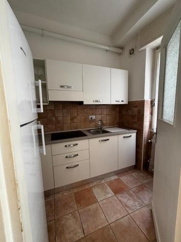 a kitchen with white cabinets and a sink at Cà di Scirocco in Varigotti