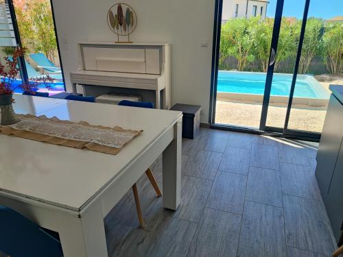 a living room with a white table and a pool at Location Saisonnière Villa in Uzès