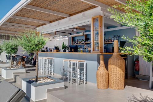 a restaurant with a bar with vases at Aegean Paradiso Vacation Club - "Adults Only" in Azolimnos