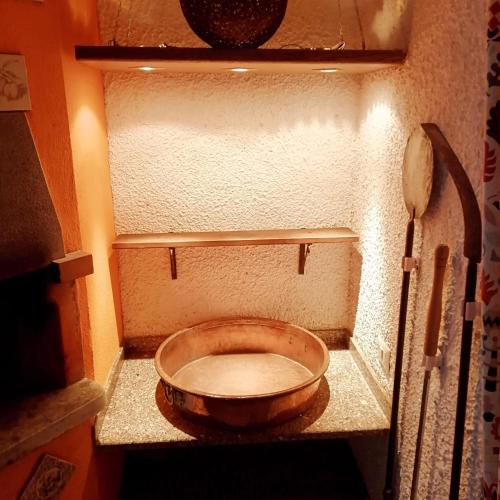 a toilet in a small room with a wooden bowl at La Casina di Sotto in Castelnuovo di Garfagnana