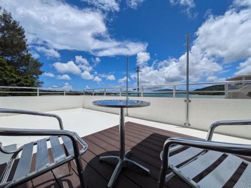 a patio with a table and chairs on a roof at 遊びの宿 海陽 in Wakugawa