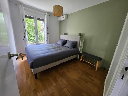 une chambre avec un lit avec des draps bleus et une fenêtre dans l'établissement Charmante villa près du centre de Bayonne et des plages, à Boucau