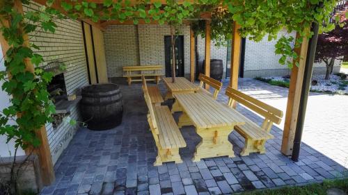 a group of benches sitting under a pergola at Hiša na Hribu- A Peaceful Hilltop Escape above river Kolpa in Kostel