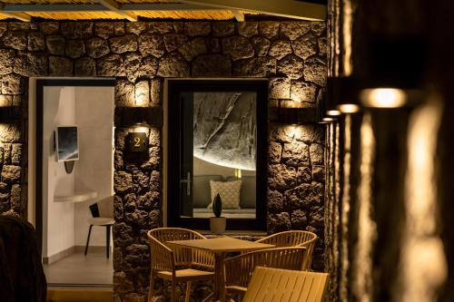 a room with a table and chairs and a mirror at Mperes Villas in Santorini