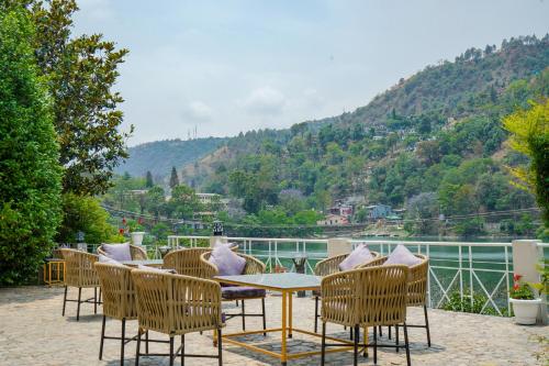 a patio with a table and chairs and a mountain at Neelesh Inn- A Luxury Lake View Hotel- 20 kms from Nainital in Bhīm Tāl