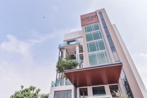 an office building with a curved facade at Mayuu Ayutthaya Hotel in Ban Ko Rian
