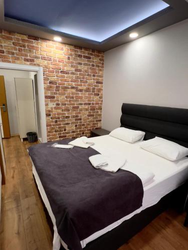a large bed in a room with a brick wall at Kuloğlu Otel ve Restoran in Uzungol