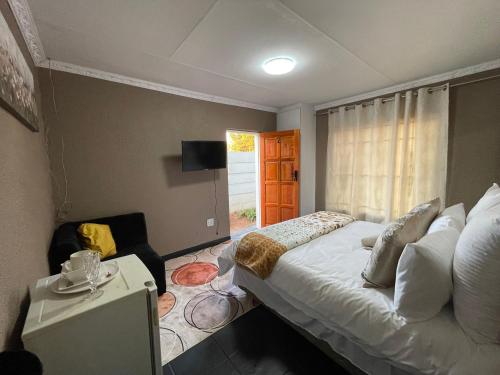 a bedroom with a large bed and a window at Homely Home Guest House in Roodepoort
