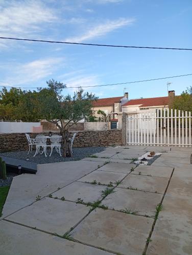 a patio with a table and a tree and a fence at Casa da Marquinhas in Ventozelo