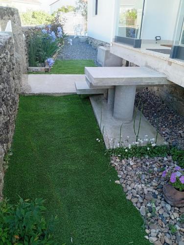 a bench sitting in the grass next to a building at Casa da Marquinhas in Ventozelo