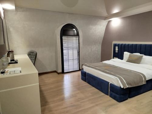a bedroom with a bed and a table and a window at DADIANI Inn in Zugdidi