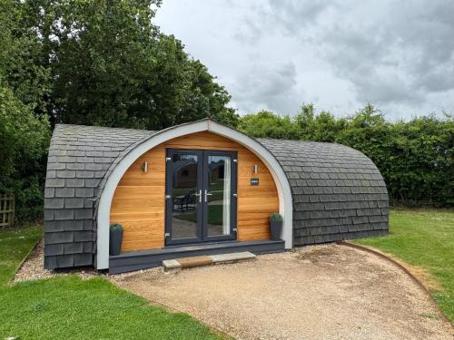 a small cabin with a grey roof at All Manor Of Events - Glamping Pods in Henley